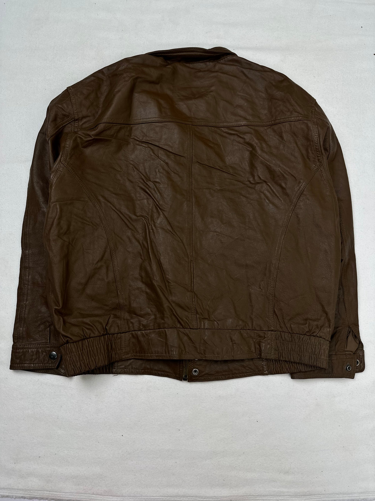 Back of the size M brown leather flight jacket, laid flat