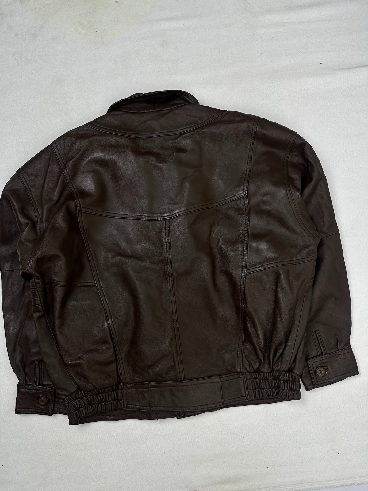Back of the size L brown leather flight jacket, laid flat