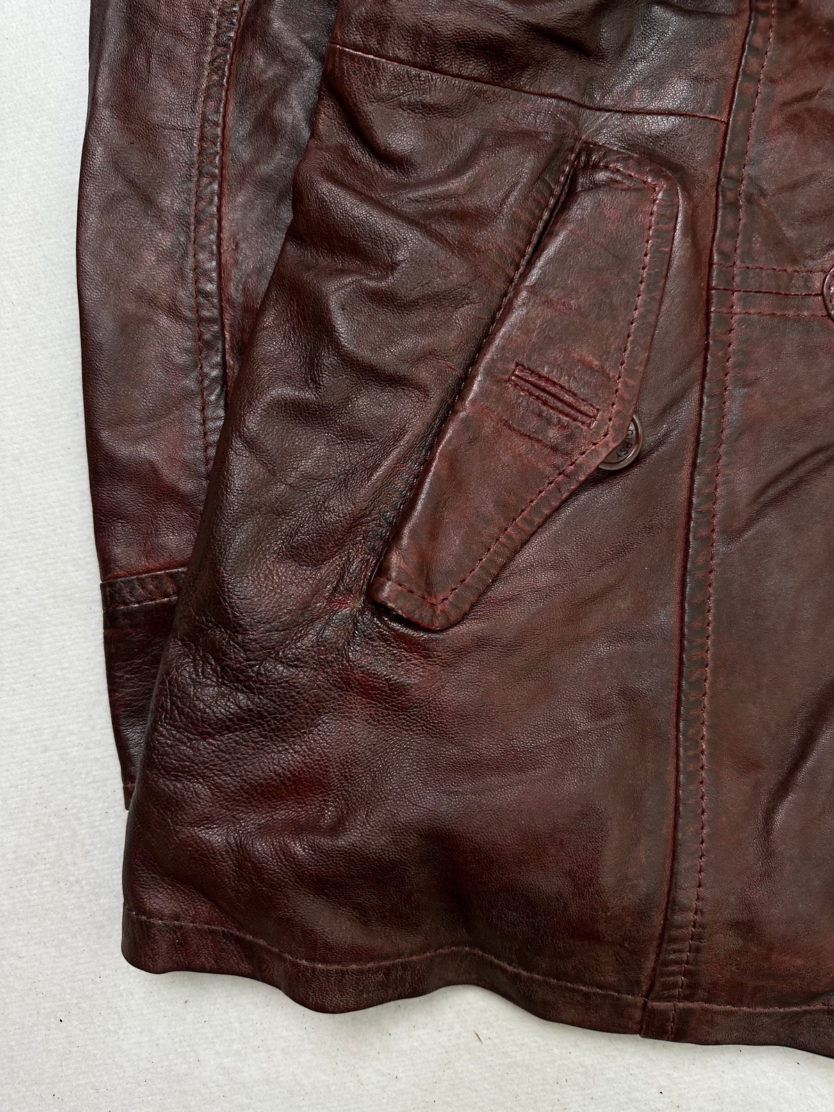 Close detail of the pockets and cuff on the size L burgundy leather hooded jacket