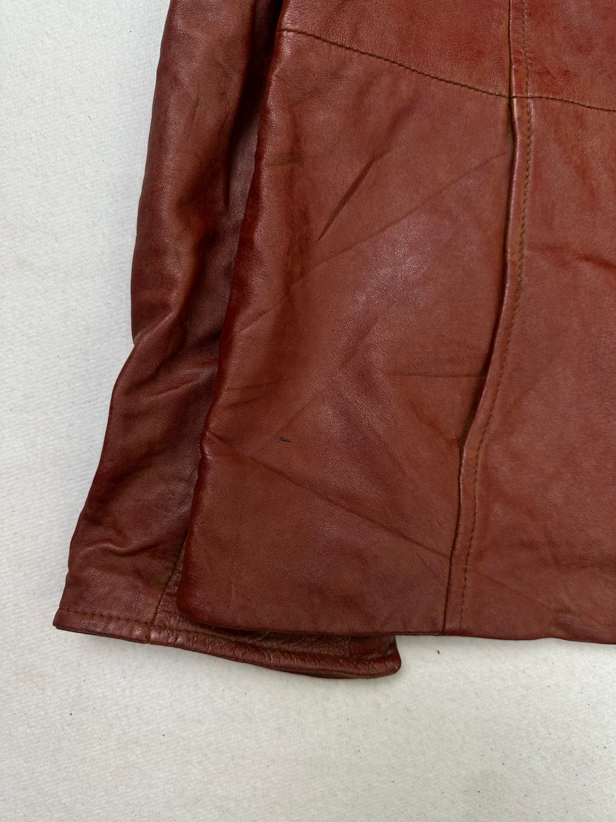 Close detail of the pockets and cuff on the size S burgundy leather cafe racer jacket