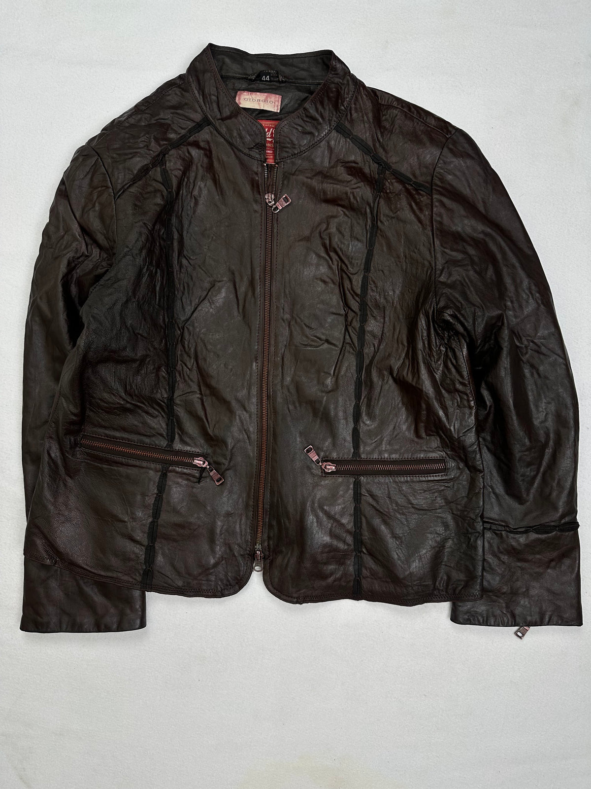 Front of the size S brown leather cafe racer jacket, laid flat and unedited