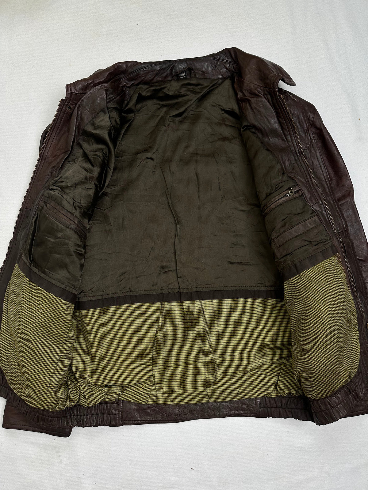 The size M burgundy leather vintage jacket opened to show the lining
