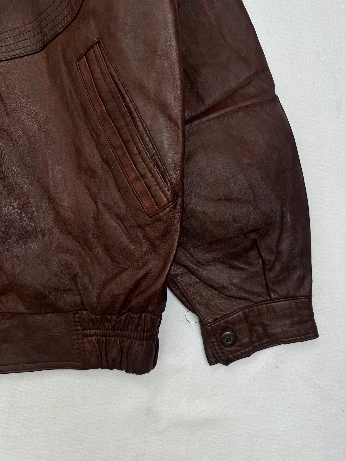 Side pocket and hem of the size XL burgundy leather harrington jacket, up close