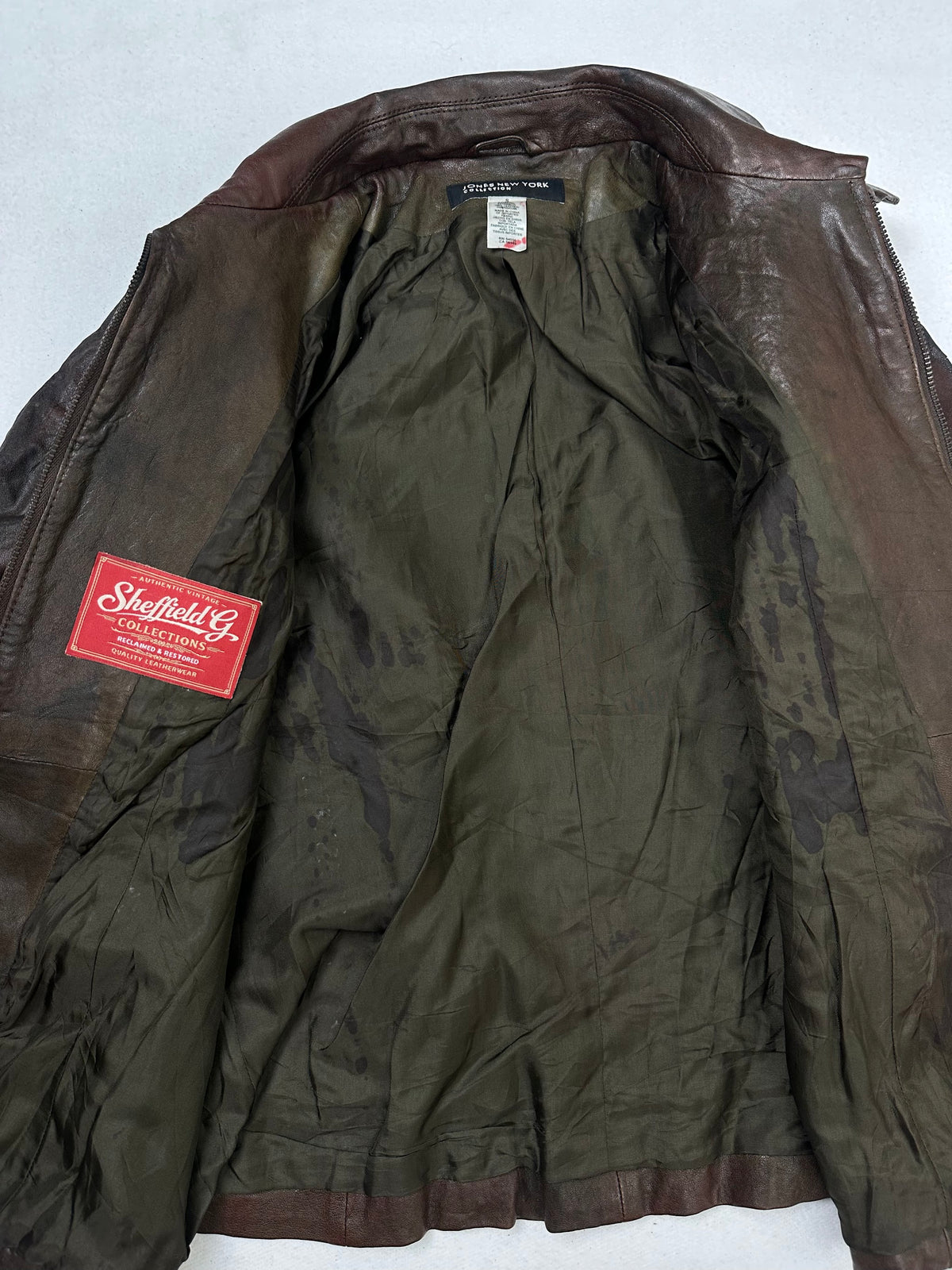 The size S burgundy leather vintage jacket opened to show the lining