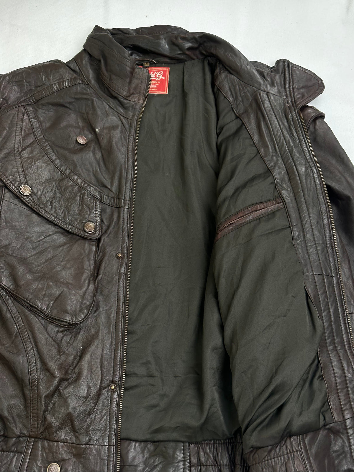 Snap flap chest pocket above a vertical zip waist pocket