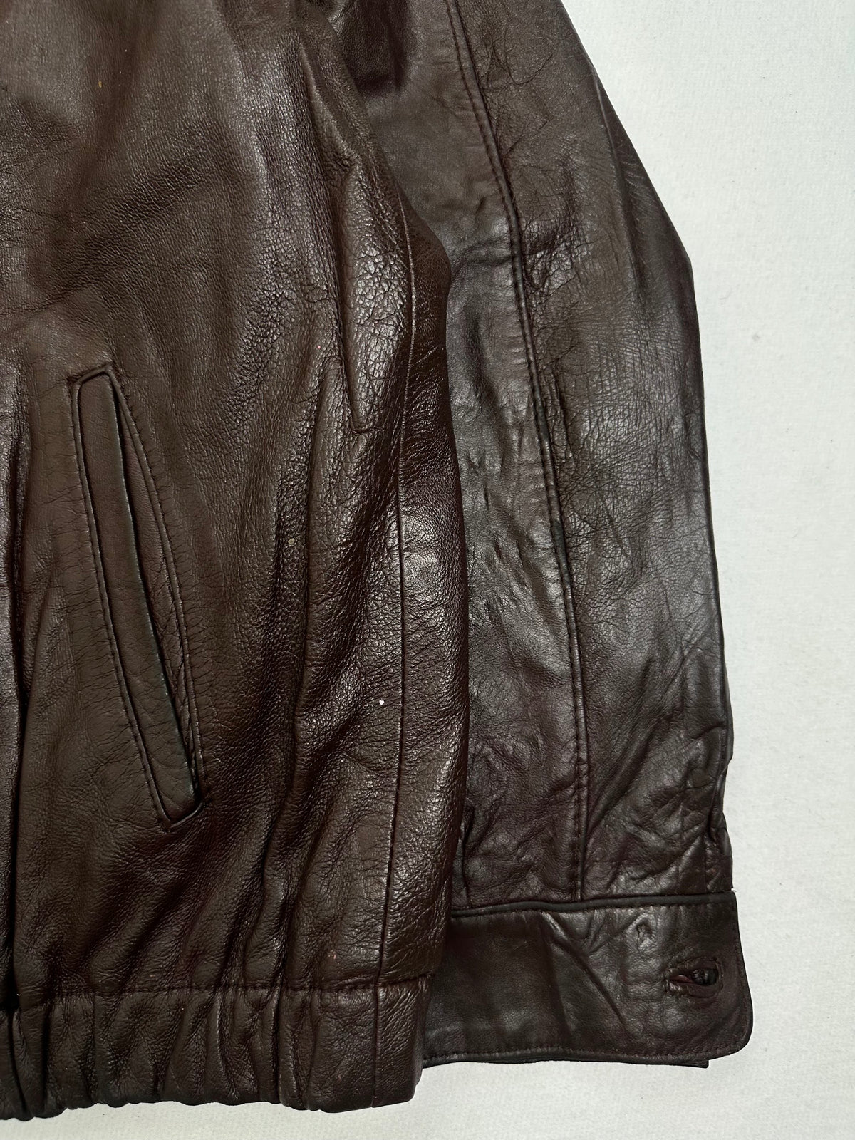 Side pocket and hem of the size M burgundy leather harrington jacket, up close