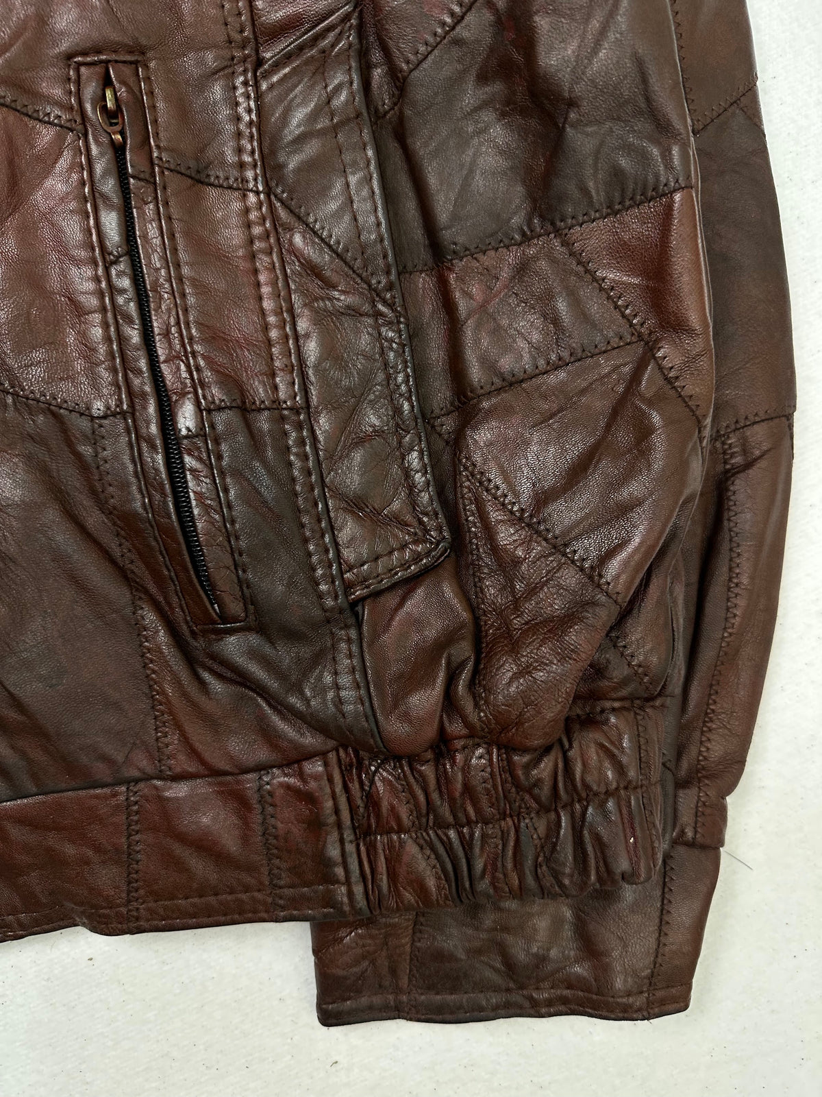 Side pocket and hem of the size XL burgundy leather flight jacket, up close