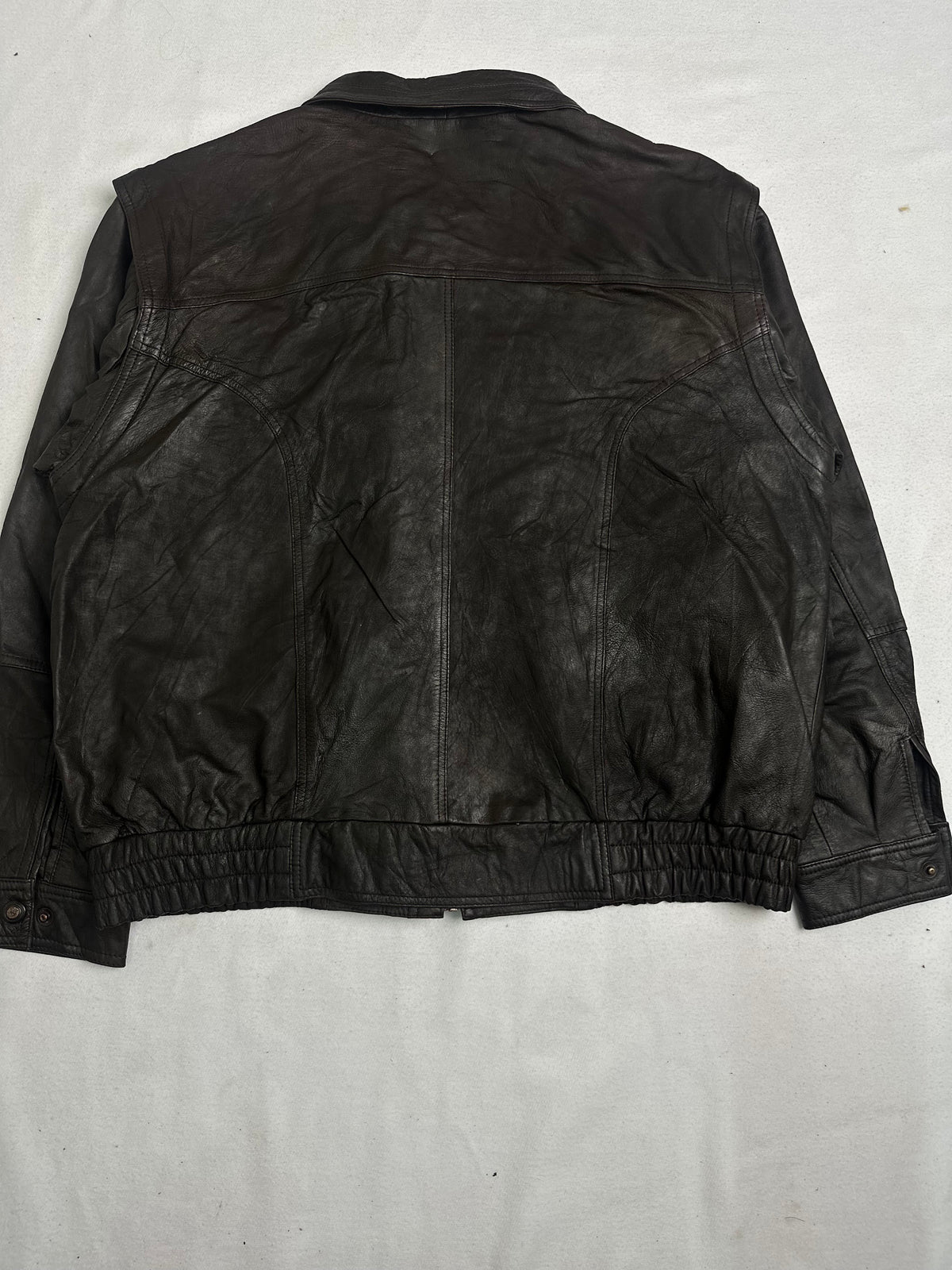 Pointed shirt collar above the studded leather storm placket