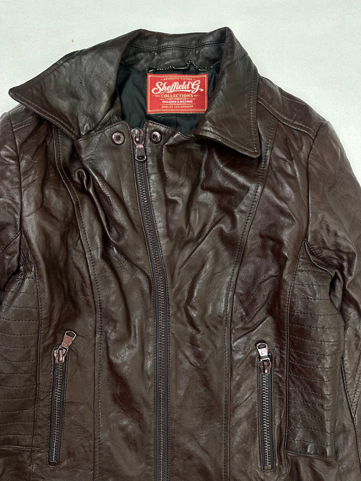 Collar and zip of the size XS burgundy leather biker jacket, up close