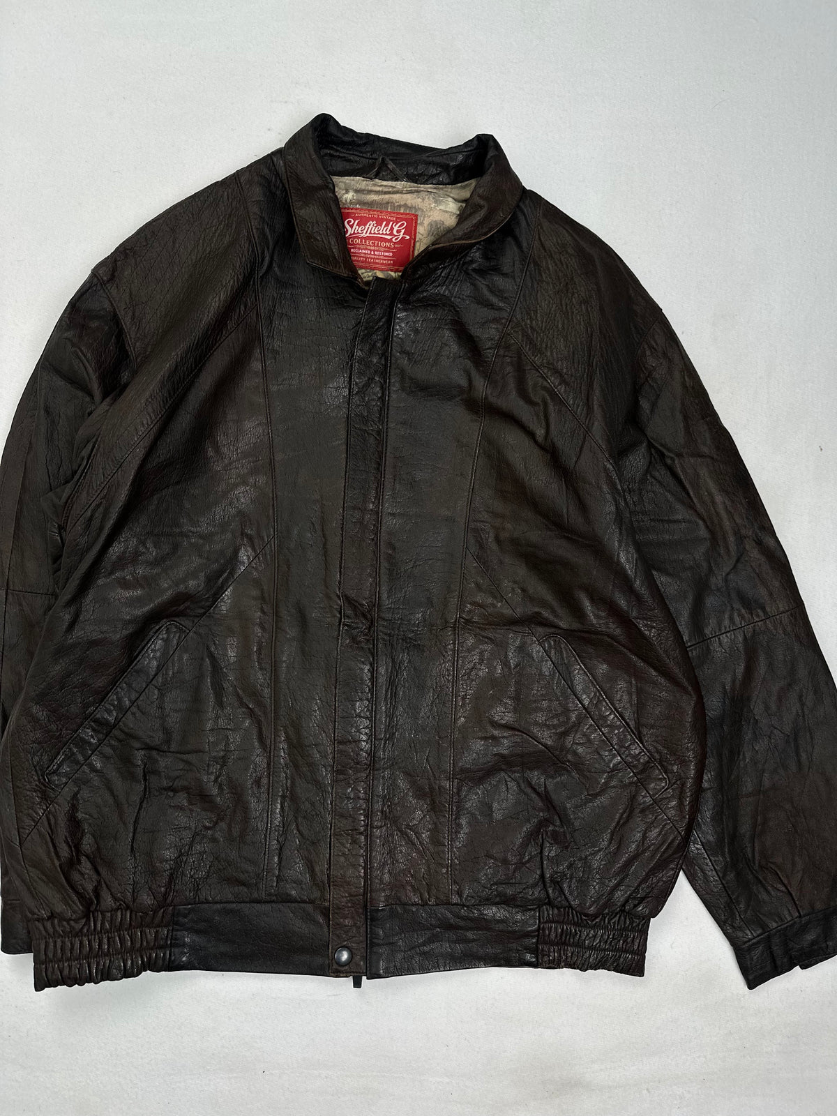 Back of the size M brown harrington jacket laid flat