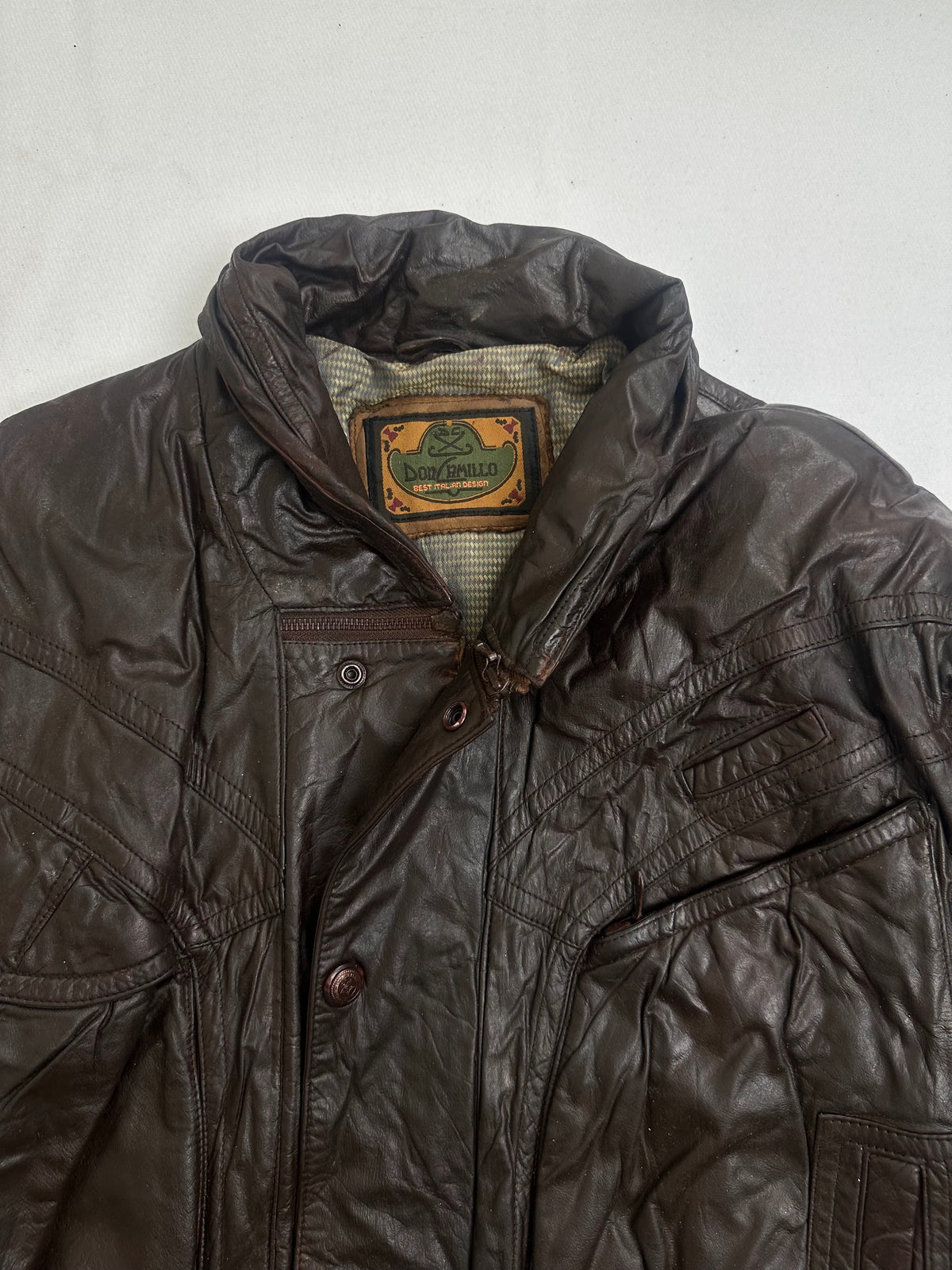Chest flap pocket above a slanted welt pocket on the brown jacket