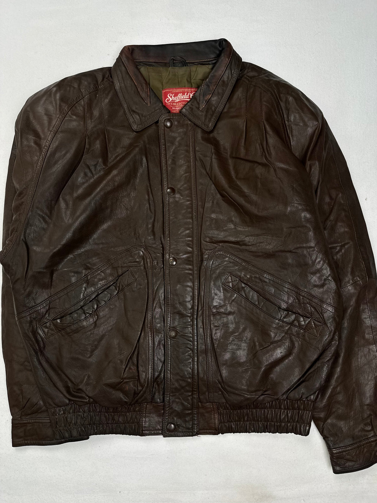 Back of the size M brown harrington jacket laid flat