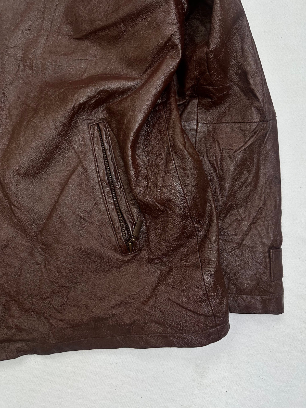 Side pocket and hem of the size L burgundy leather vintage jacket, up close