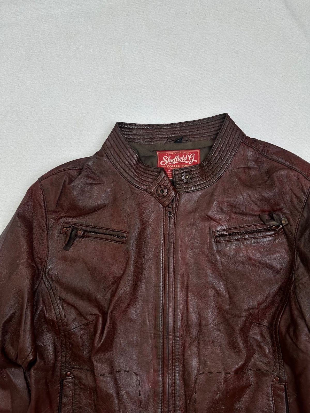 Collar and zip of the size S burgundy leather cafe racer jacket, up close