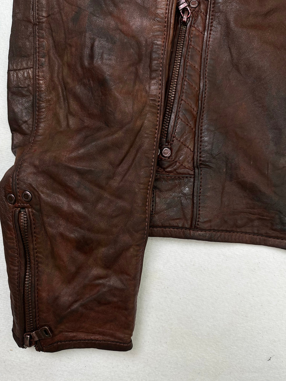 Close detail of the pockets and cuff on the size S burgundy leather cafe racer jacket