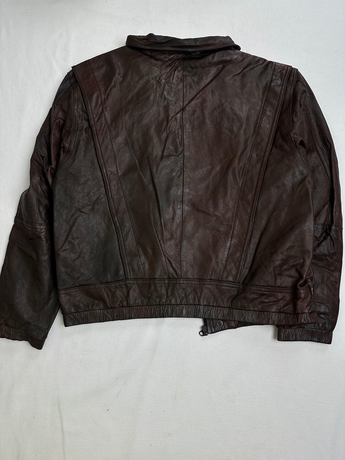 Pointed shirt collar above the snapped leather storm placket