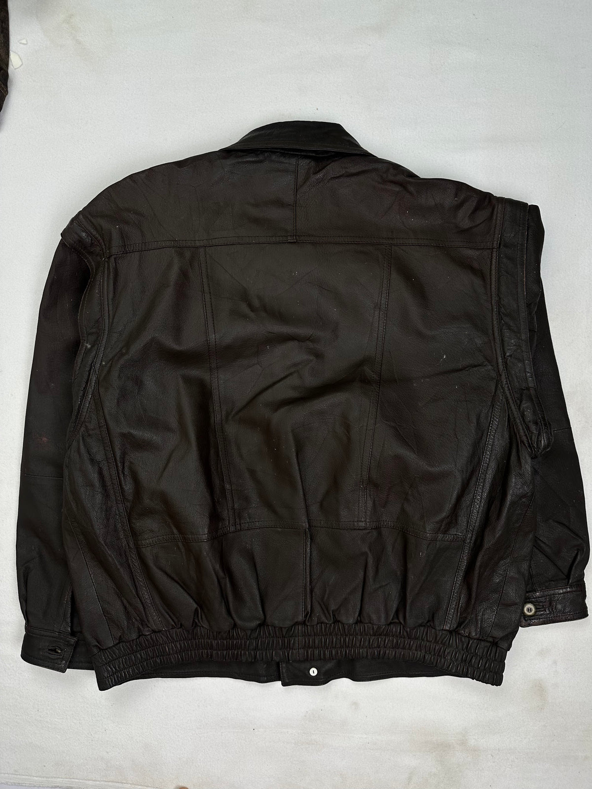 Pointed shirt collar folding over the button at the throat