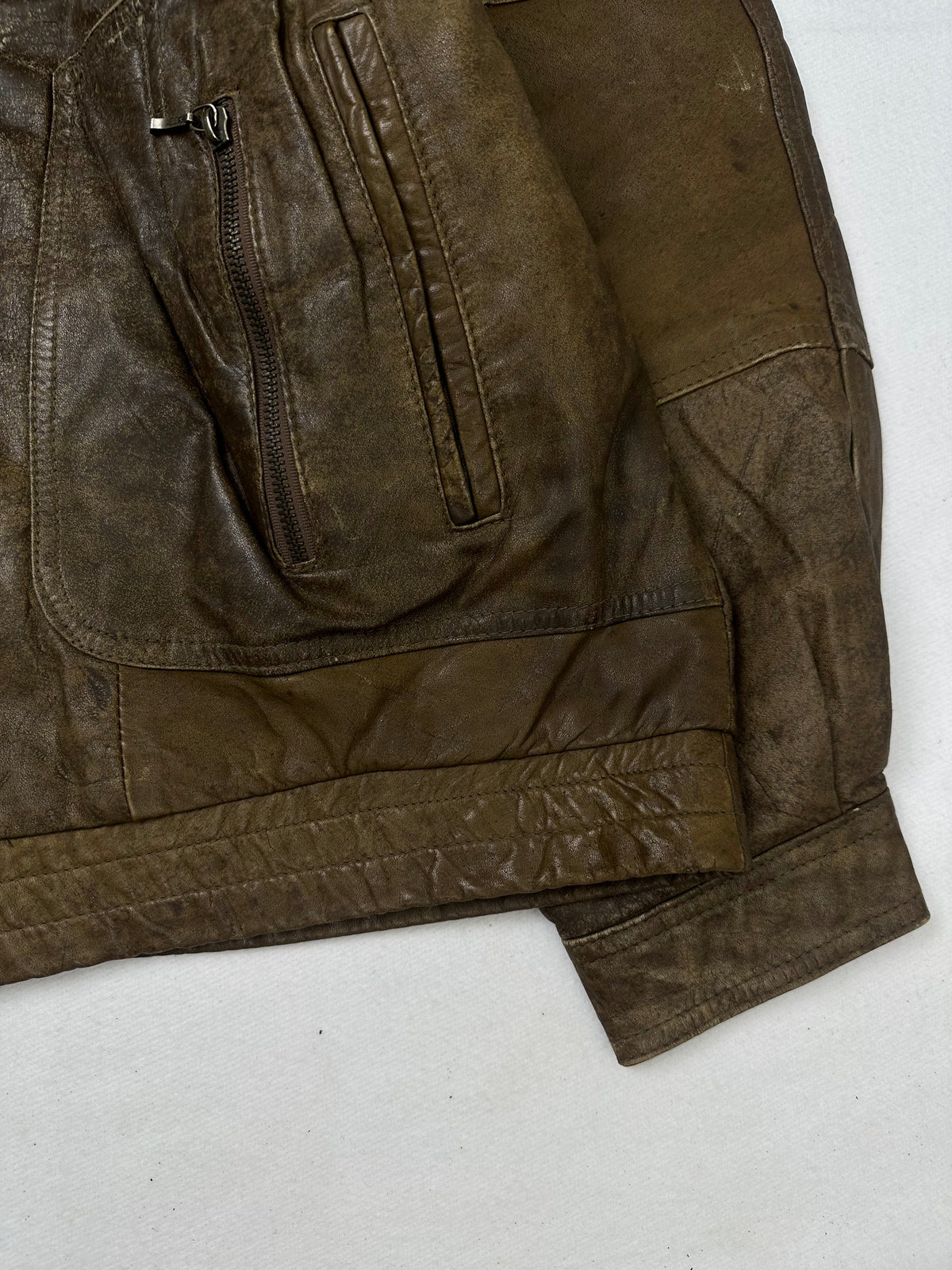 Side pocket and hem of the size L brown leather cafe racer jacket, up close
