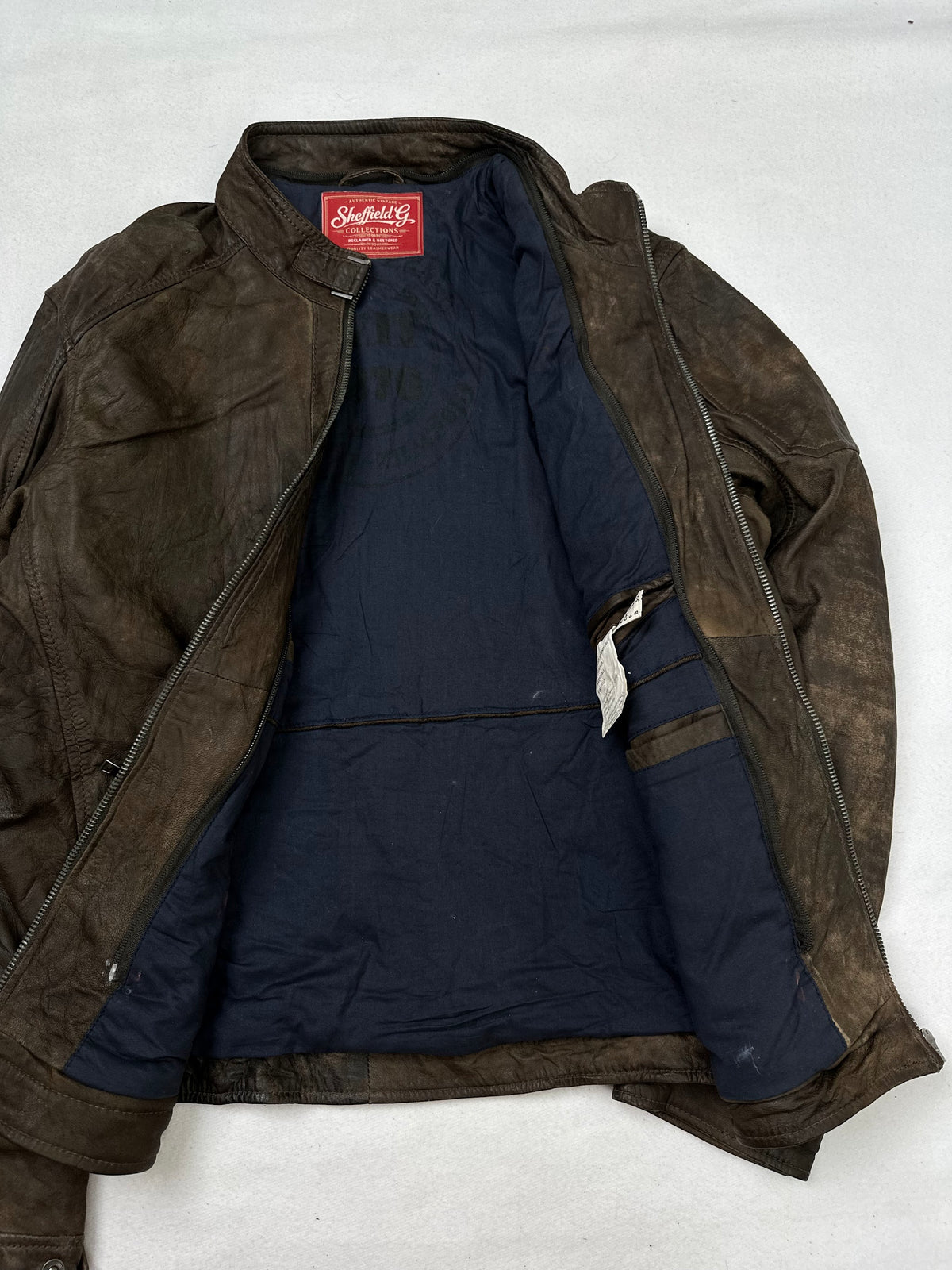 The size M brown leather cafe racer jacket opened to show the lining
