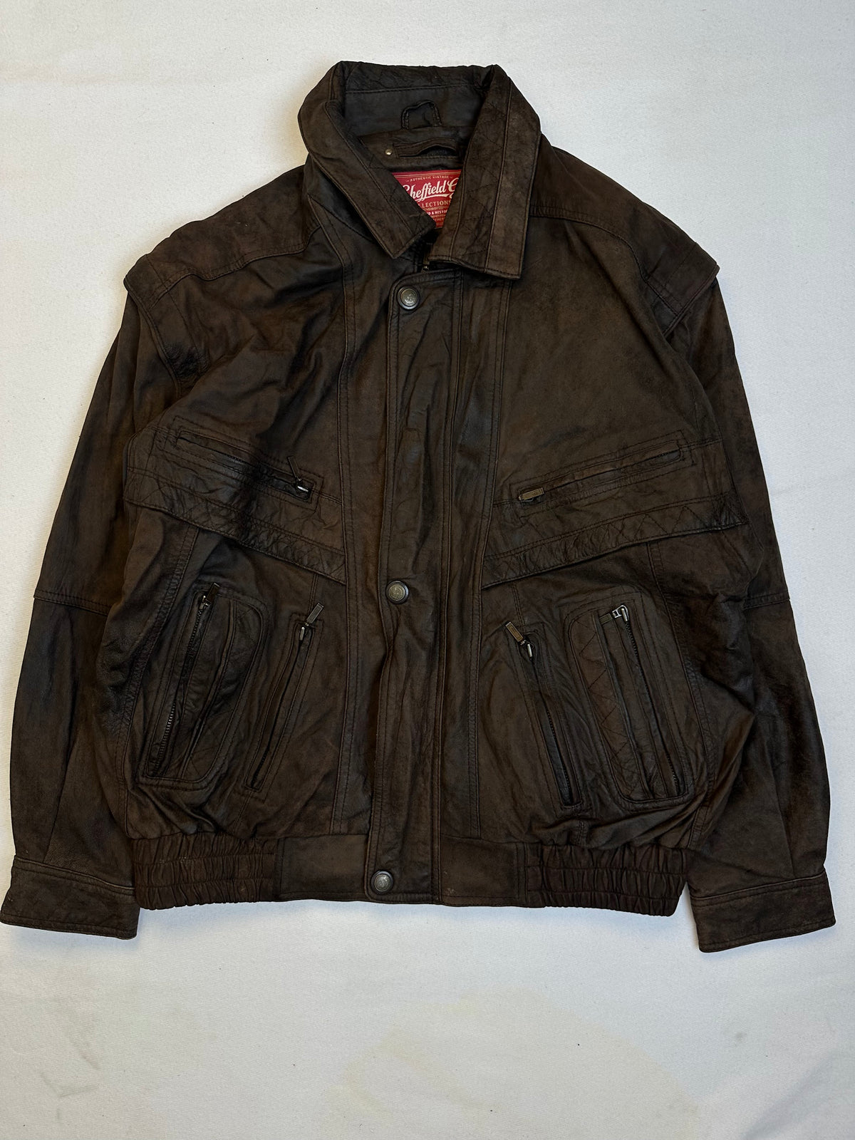 Front of the size L brown leather flight jacket, laid flat and unedited