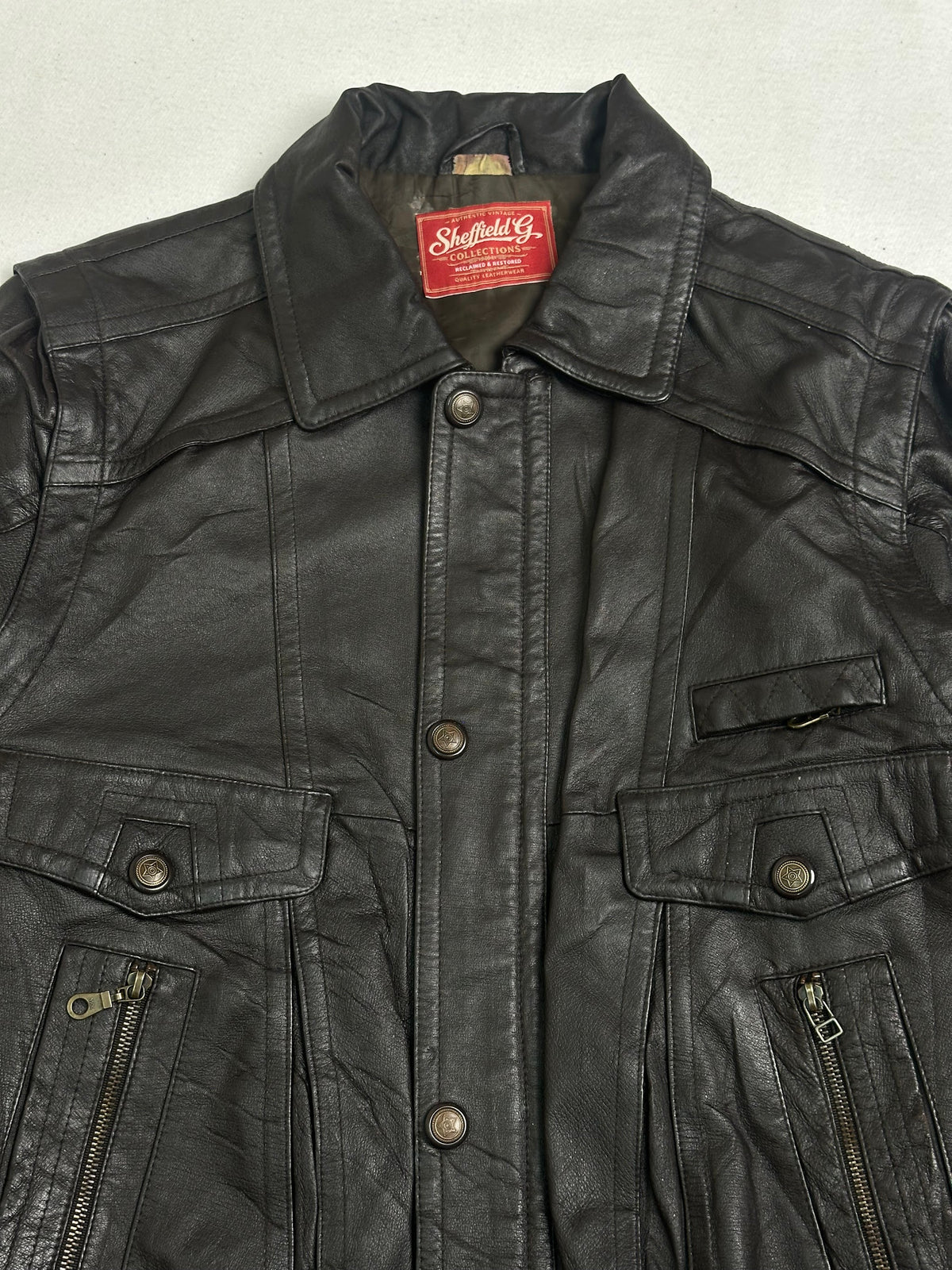 Dome snap chest flap pocket above a vertical zip pocket