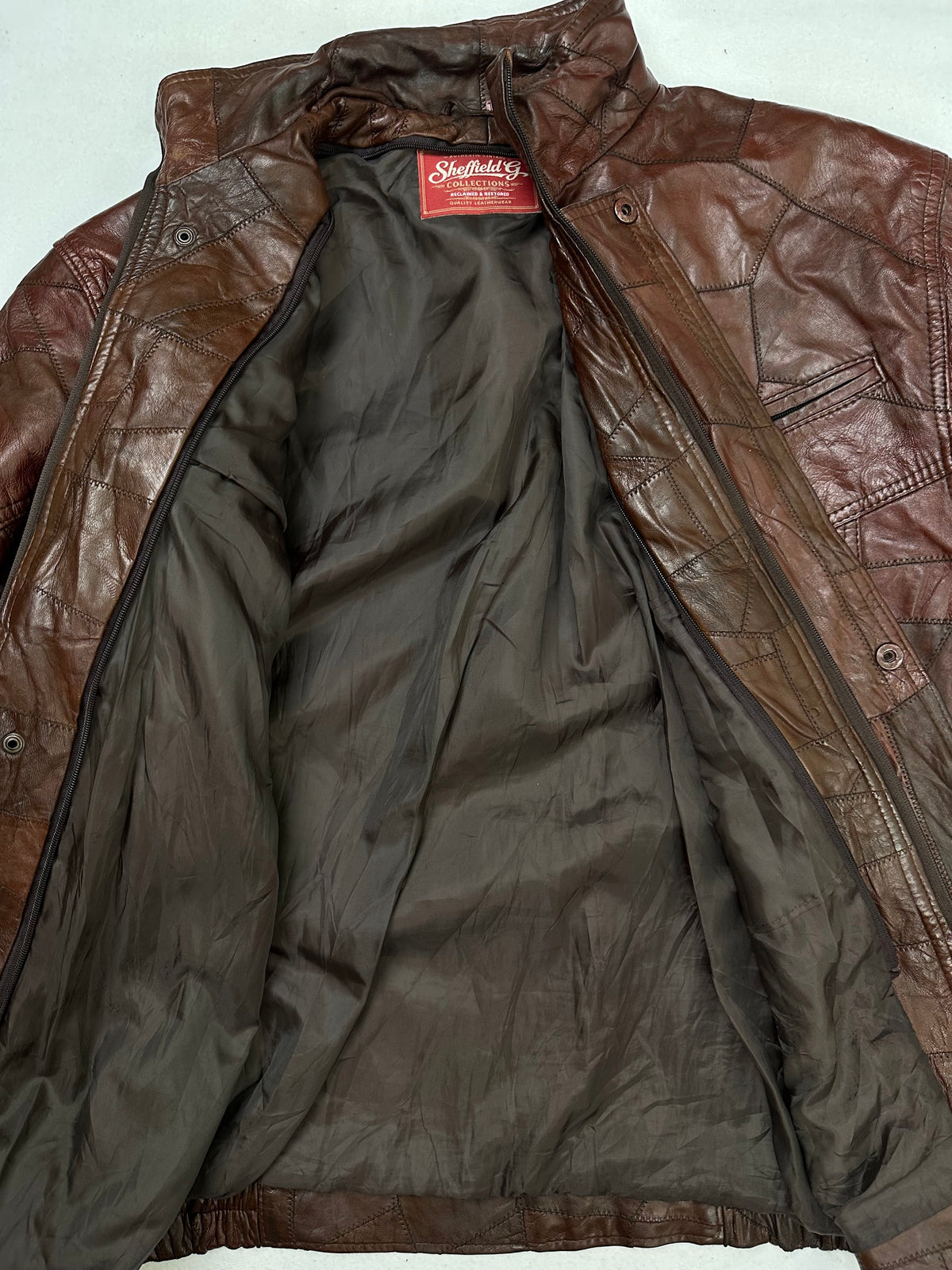 The size XL burgundy leather flight jacket opened to show the lining