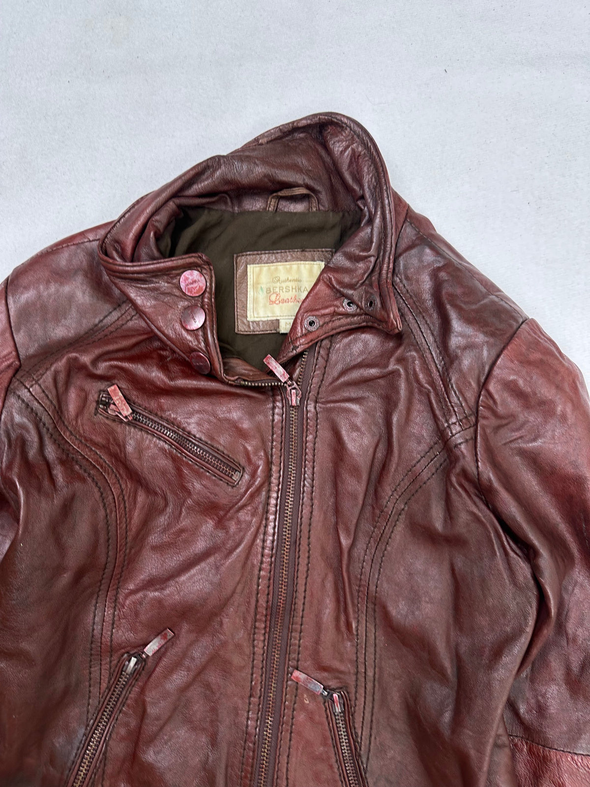 Collar and zip of the size S burgundy leather cafe racer jacket, up close