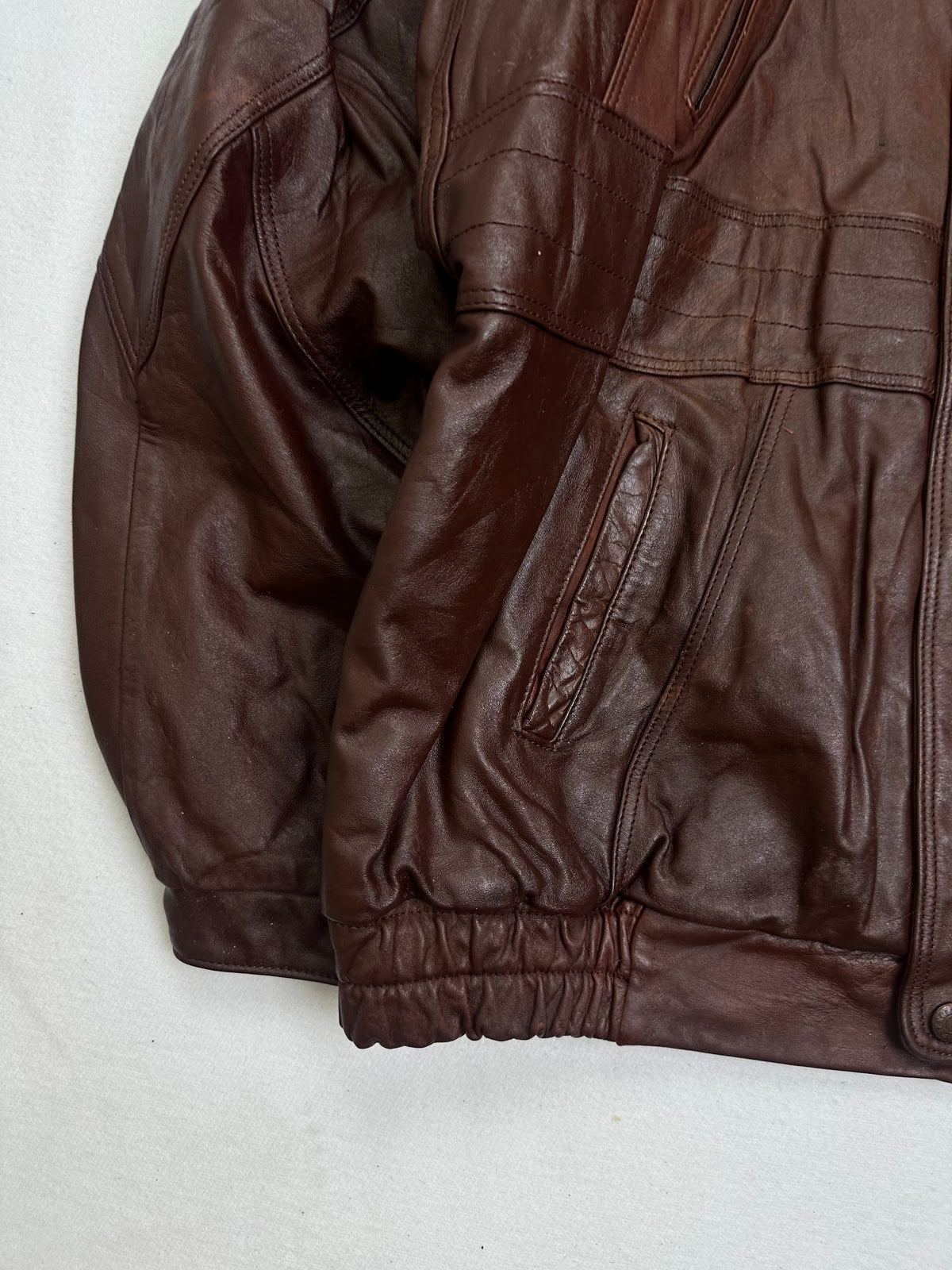 Close detail of the pockets and cuff on the size L burgundy leather vintage jacket