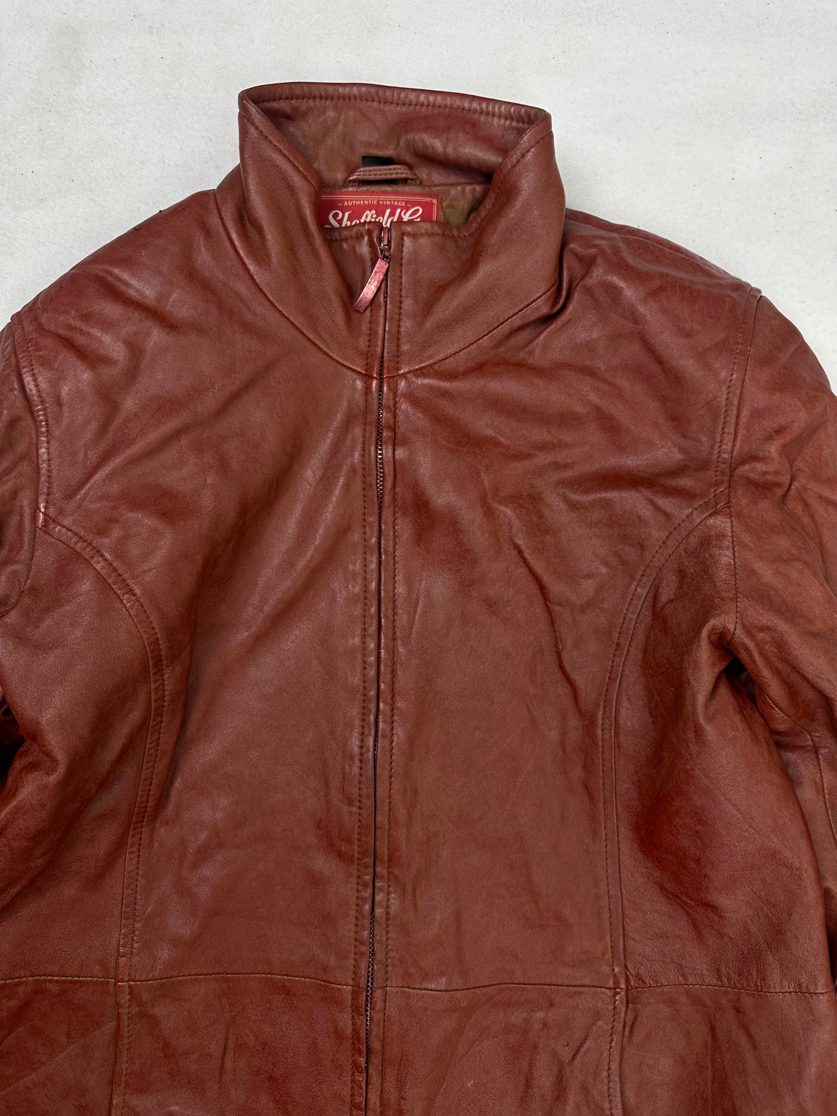 Collar and zip of the size S burgundy leather cafe racer jacket, up close