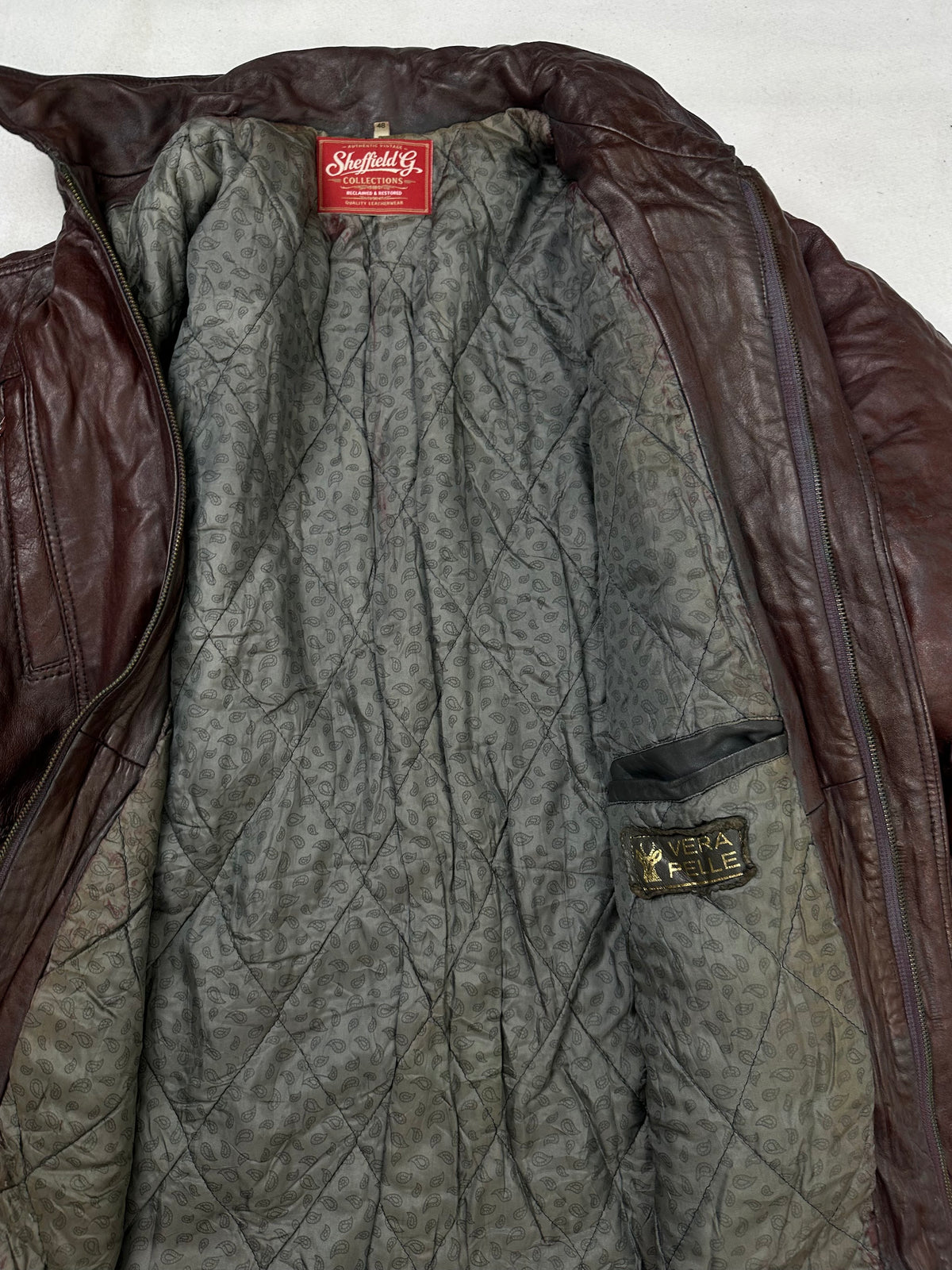 The size M burgundy leather vintage jacket opened to show the lining