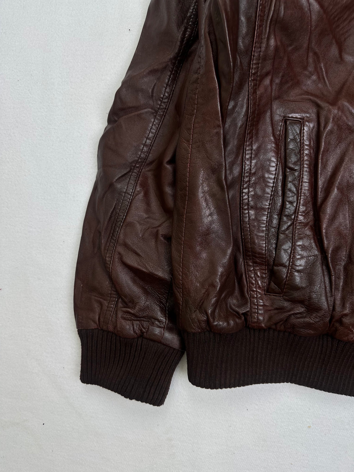 Close detail of the pockets and cuff on the size XL burgundy leather bomber jacket