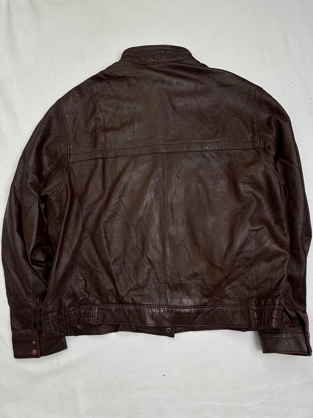 Back of the size L burgundy leather vintage jacket, laid flat