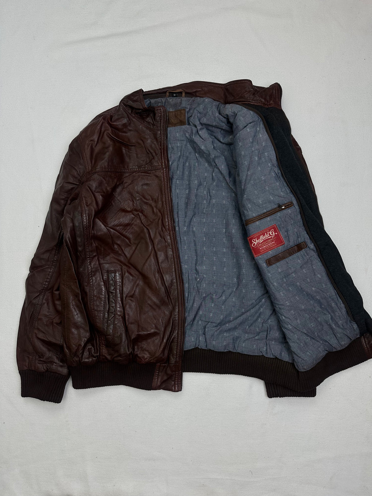 The size XL burgundy leather bomber jacket opened to show the lining