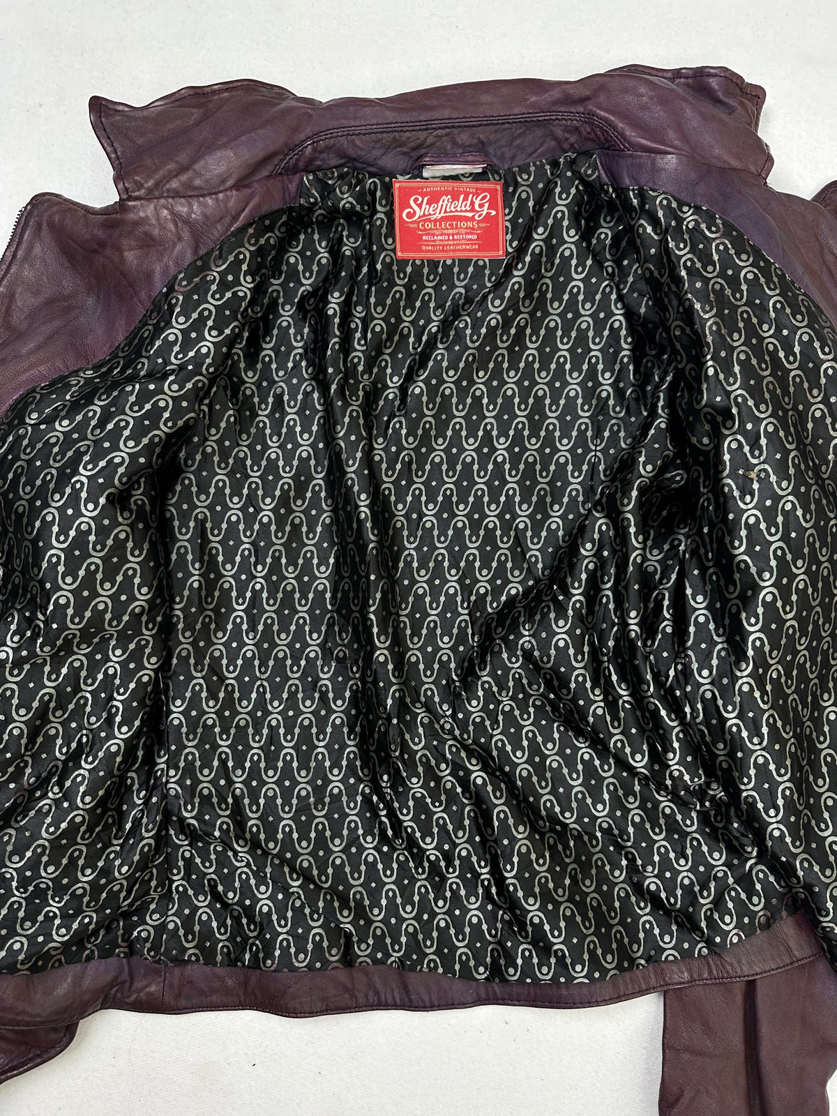 The size S burgundy leather biker jacket opened to show the lining