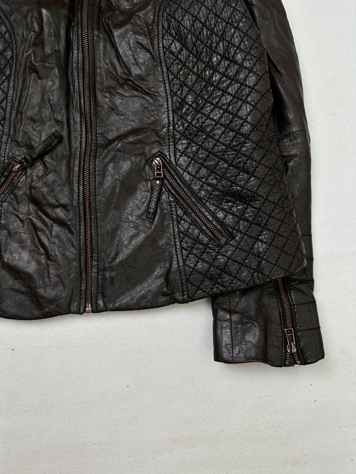Side pocket and hem of the size S brown leather cafe racer jacket, up close