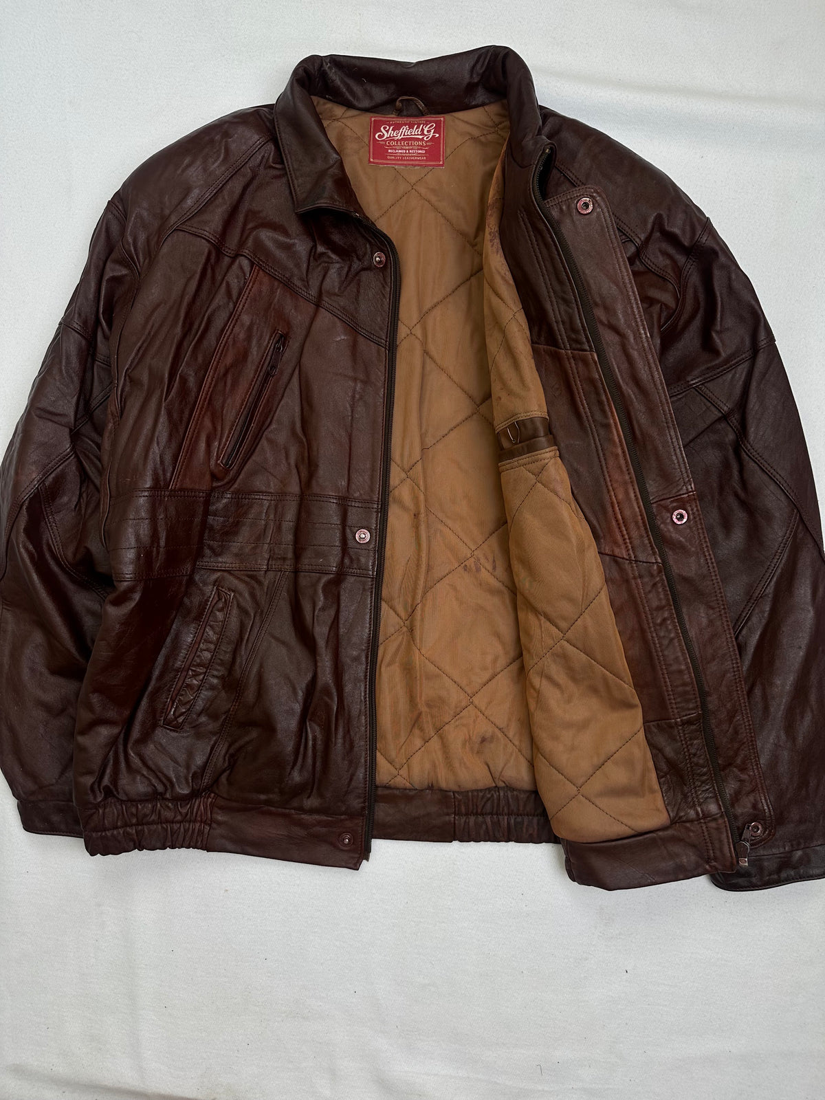 The size L burgundy leather vintage jacket opened to show the lining