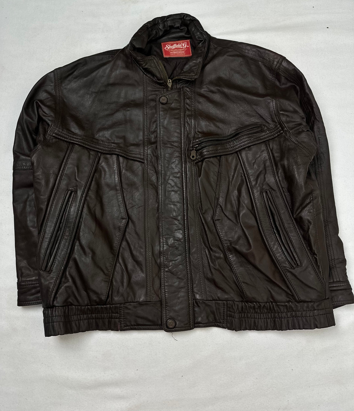 Front of the size XL brown leather flight jacket, laid flat and unedited