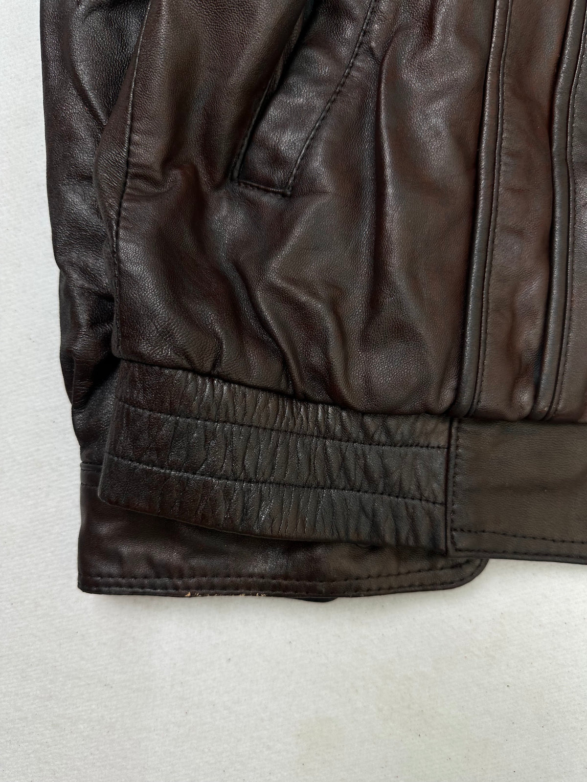 Close detail of the pockets and cuff on the size L burgundy leather cafe racer jacket