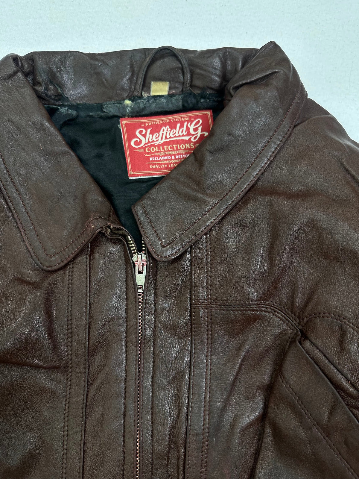 Collar and zip of the size L burgundy leather flight jacket, up close