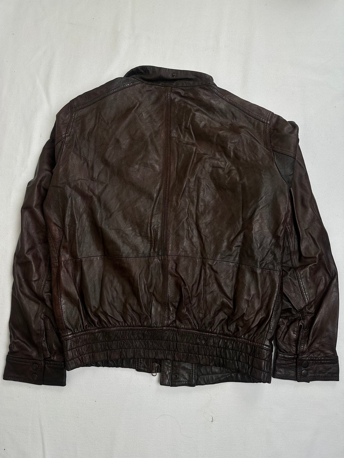 Stand collar snapping at the throat above the storm placket