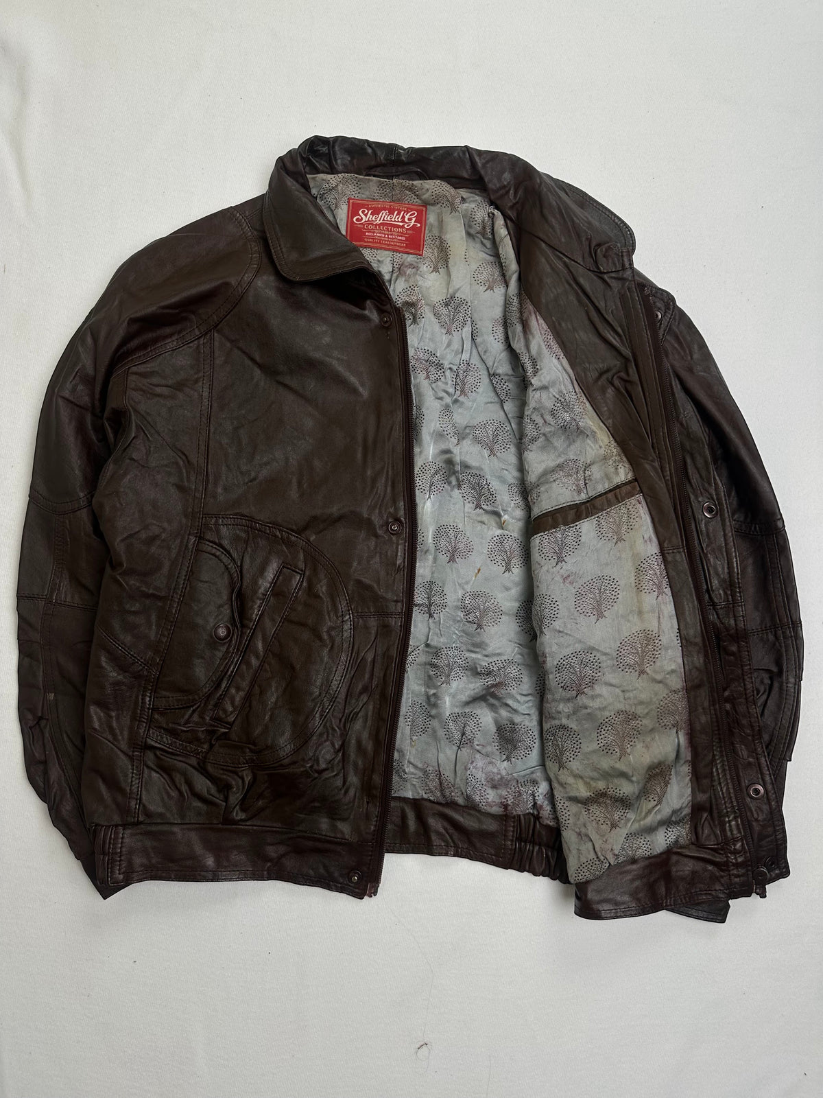 Grey printed leaf motif lining shown with the brown harrington open