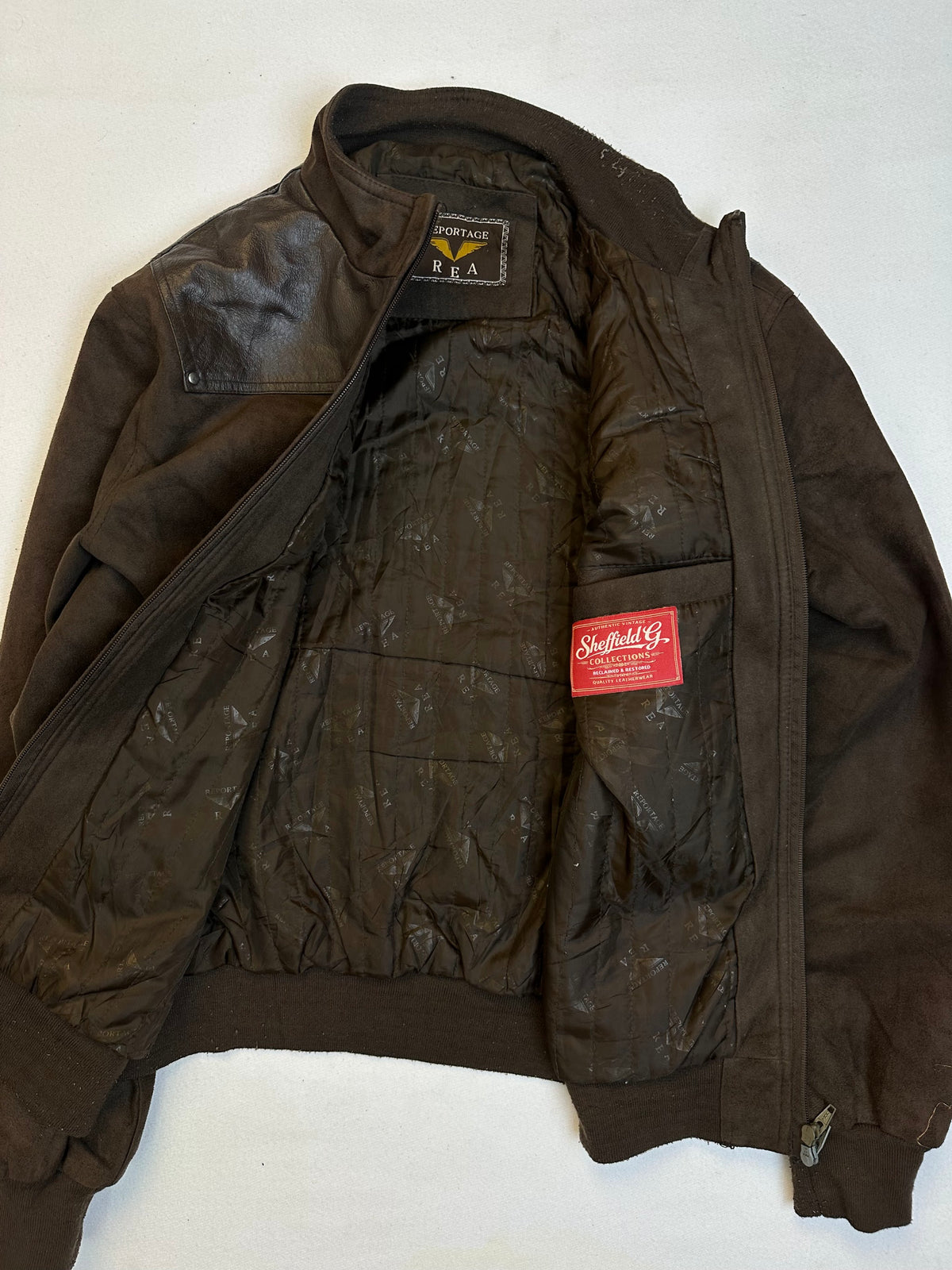 The size L brown leather cafe racer jacket opened to show the lining