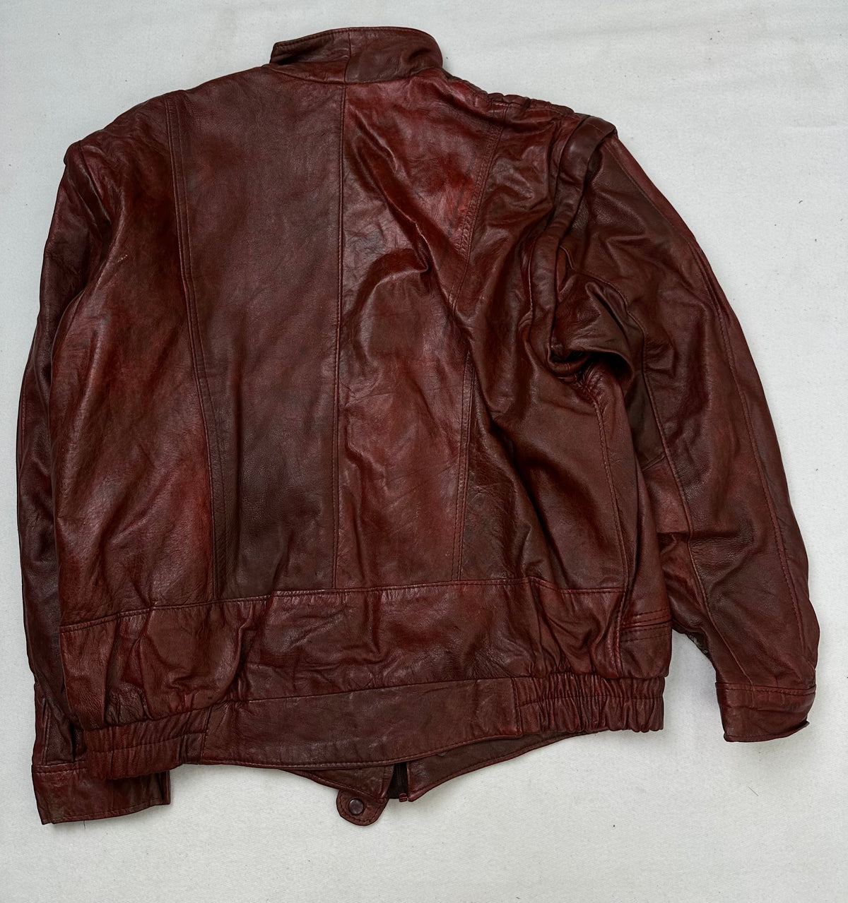 Back of the size L burgundy leather flight jacket, laid flat