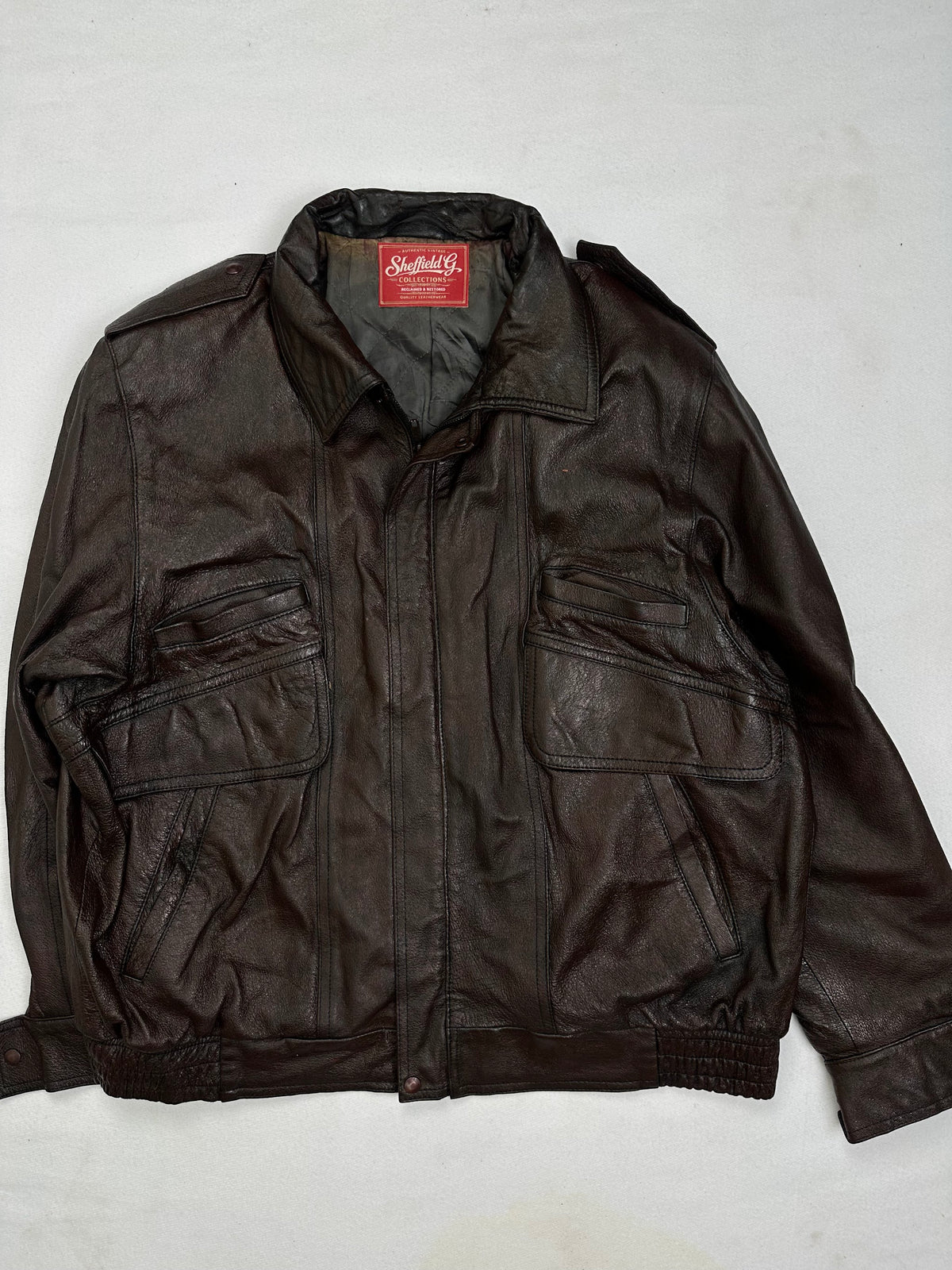 Front of the size L brown leather flight jacket, laid flat and unedited