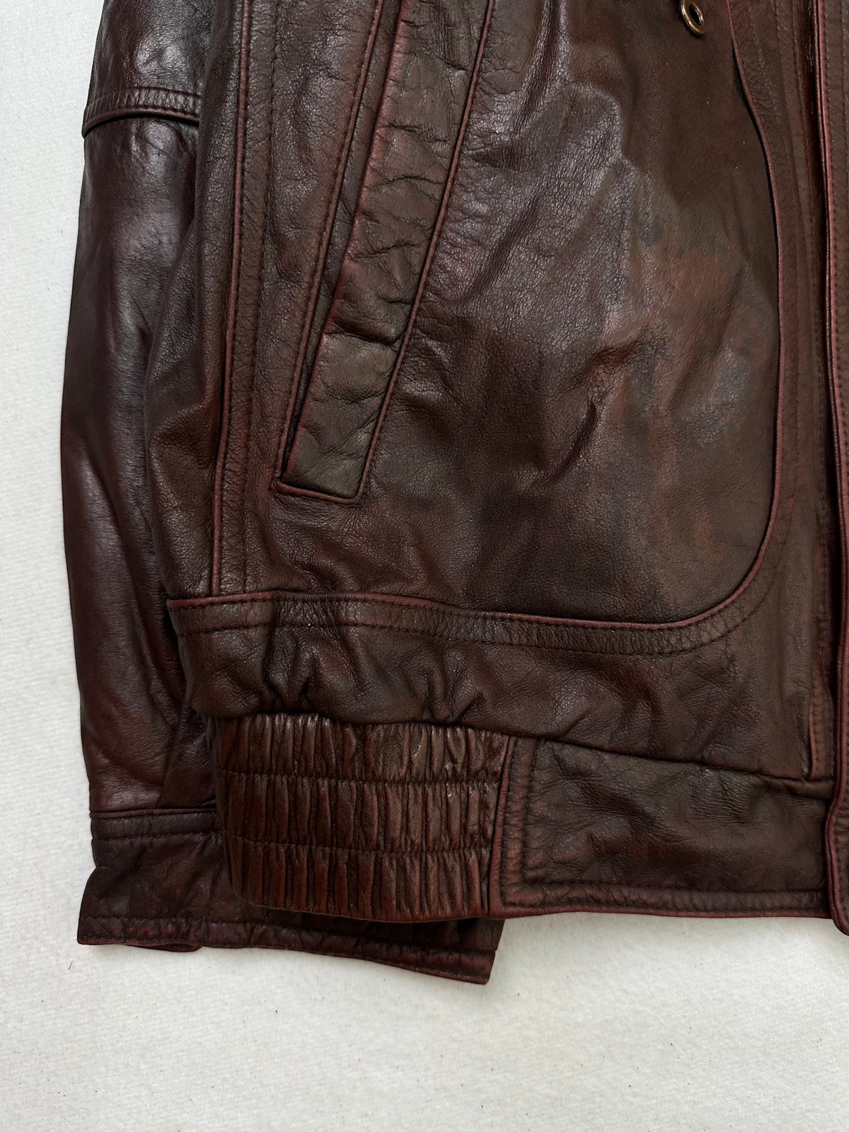 Close detail of the pockets and cuff on the size L burgundy leather flight jacket