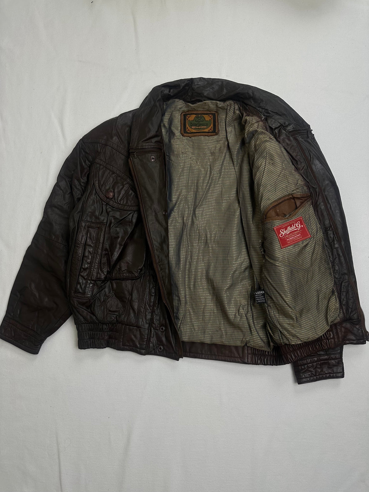 Olive check lining and its inside patch pocket on the brown flight jacket
