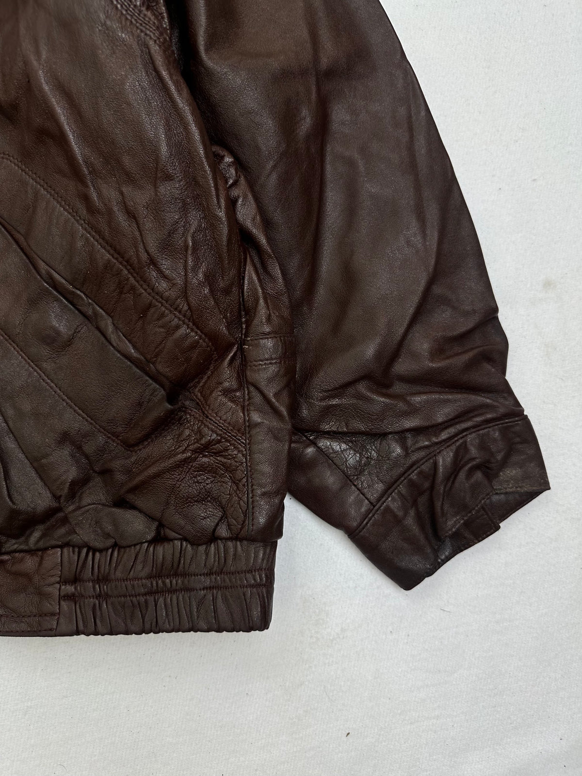 Side pocket and hem of the size L burgundy leather flight jacket, up close