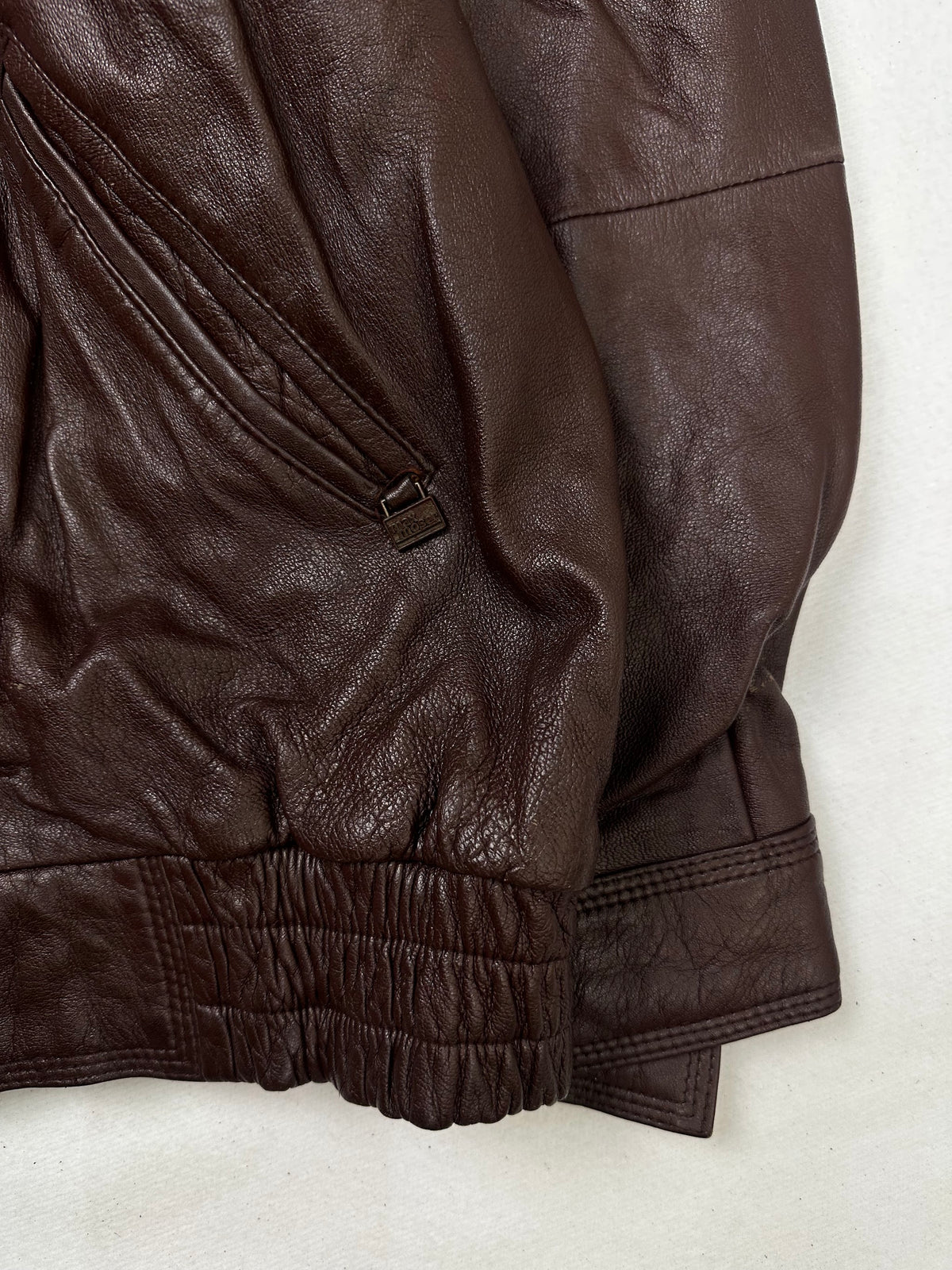Side pocket and hem of the size L burgundy leather harrington jacket, up close