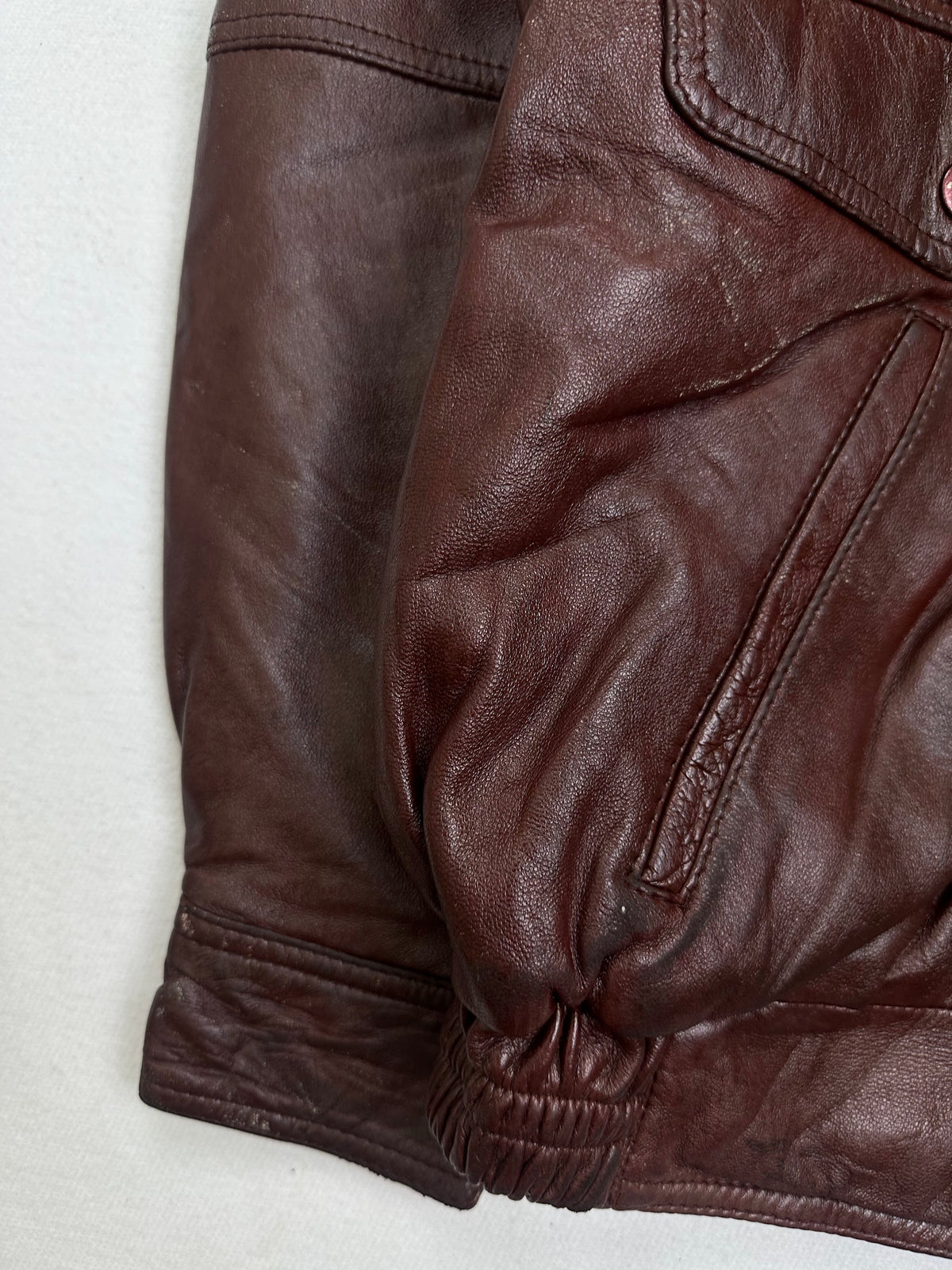 Close detail of the pockets and cuff on the size L burgundy leather flight jacket