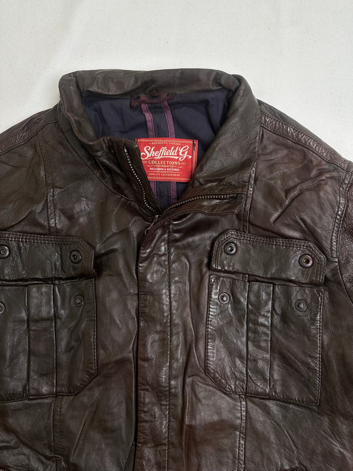 Navy lining shown with the brown flight jacket held open